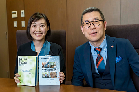 韓学長（写真右）に笑顔で受賞をご報告する足立先生（写真左）